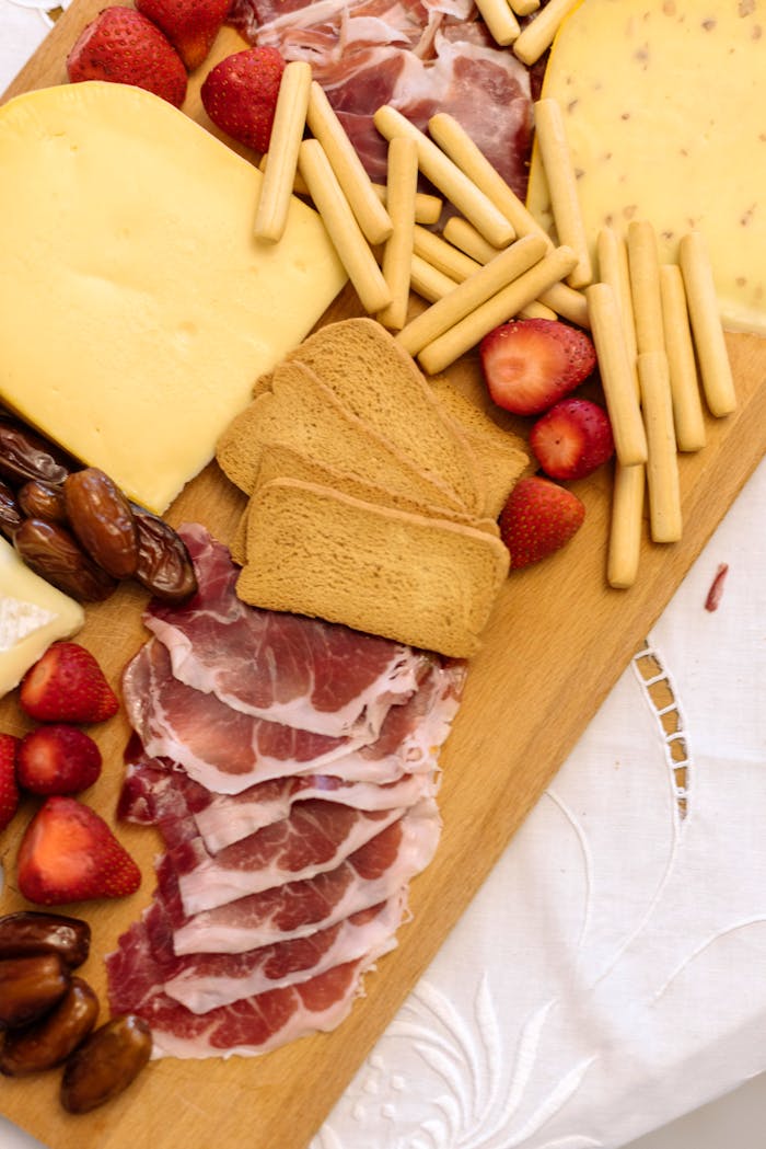 Captivating charcuterie board featuring cured meats, cheeses, and fresh fruits on a wooden tray.
